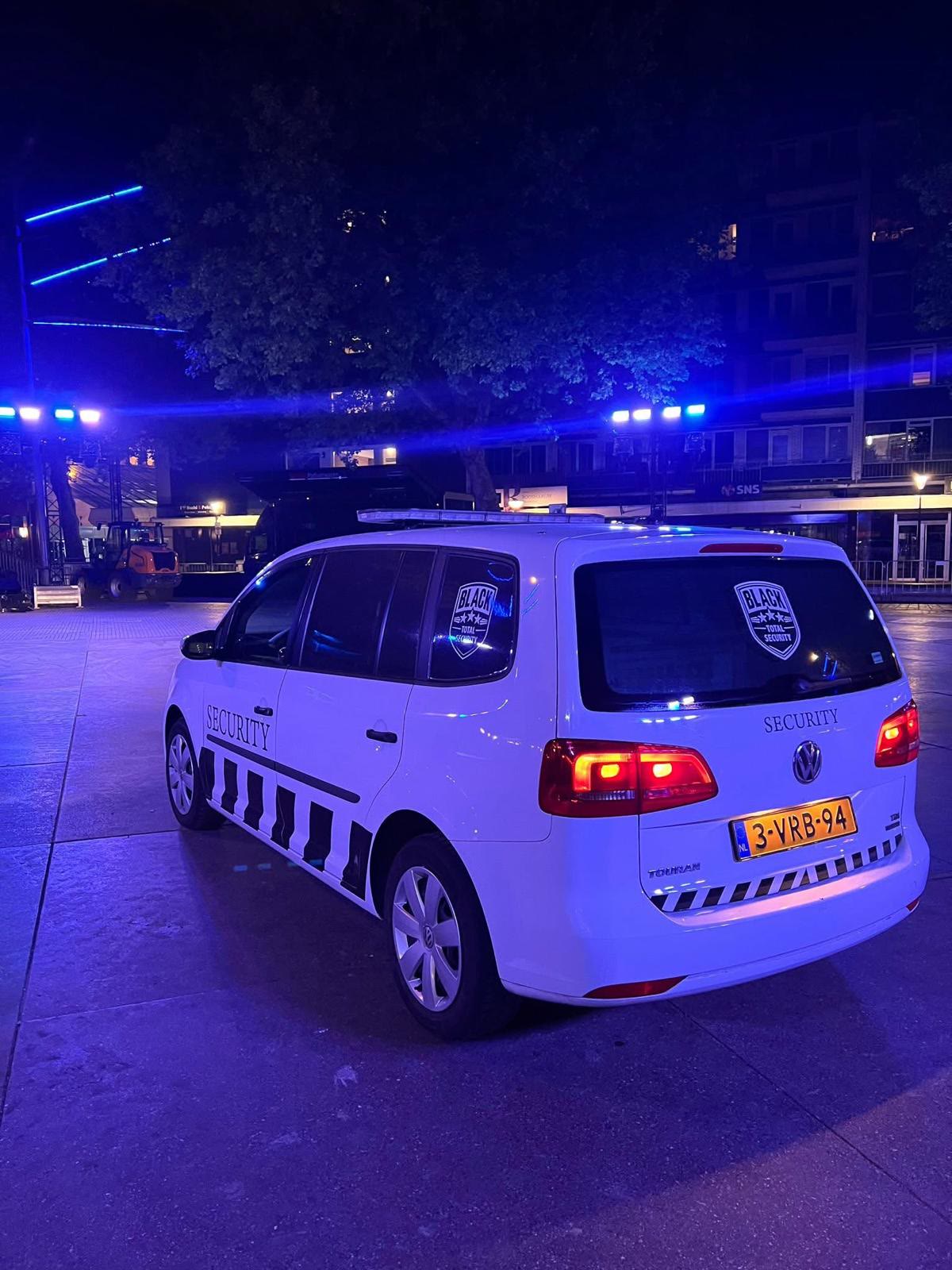 Surveillancevoertuig van Black Total Security in het blauwe licht van de avond